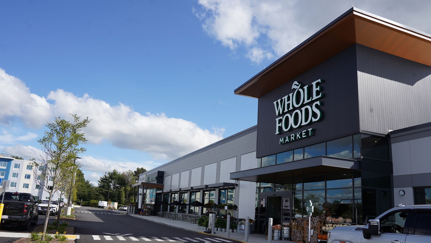 Whole Foods Market exterior with metal wall panels, storefront glazing and a wood-tone canopy